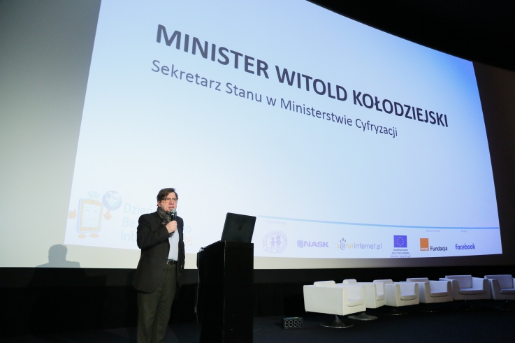 Witold Kołodziejski - sekretarz stanu na tle ekranu.
