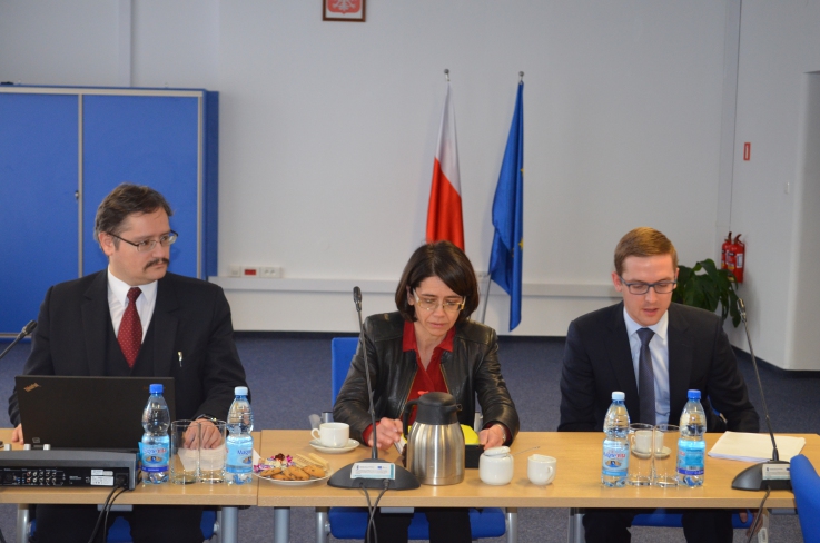 Zdjęcie przedstawia trzy osoby siedzące przy stole. Wśród nich m.in. minister Anna Streżyńska oraz wiceminister Szymon Ruman.